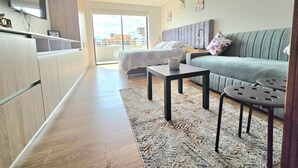 Un salon moderne avec un canapé, une table basse et un lit.