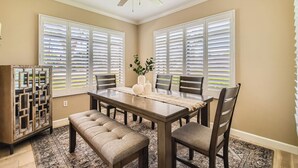 A dining room with a dark wooden table, six chairs, a bench, and a ceiling fan. - Scottsdale 3BR Kierland Condo—Pool, Hot Tub, TPC (Scottsdale)