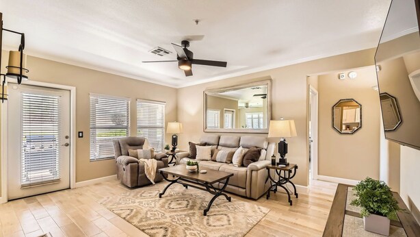 A spacious living room with a ceiling fan, a large mirror, and a wooden floor. - Scottsdale 3BR Kierland Condo—Pool, Hot Tub, TPC (Scottsdale)