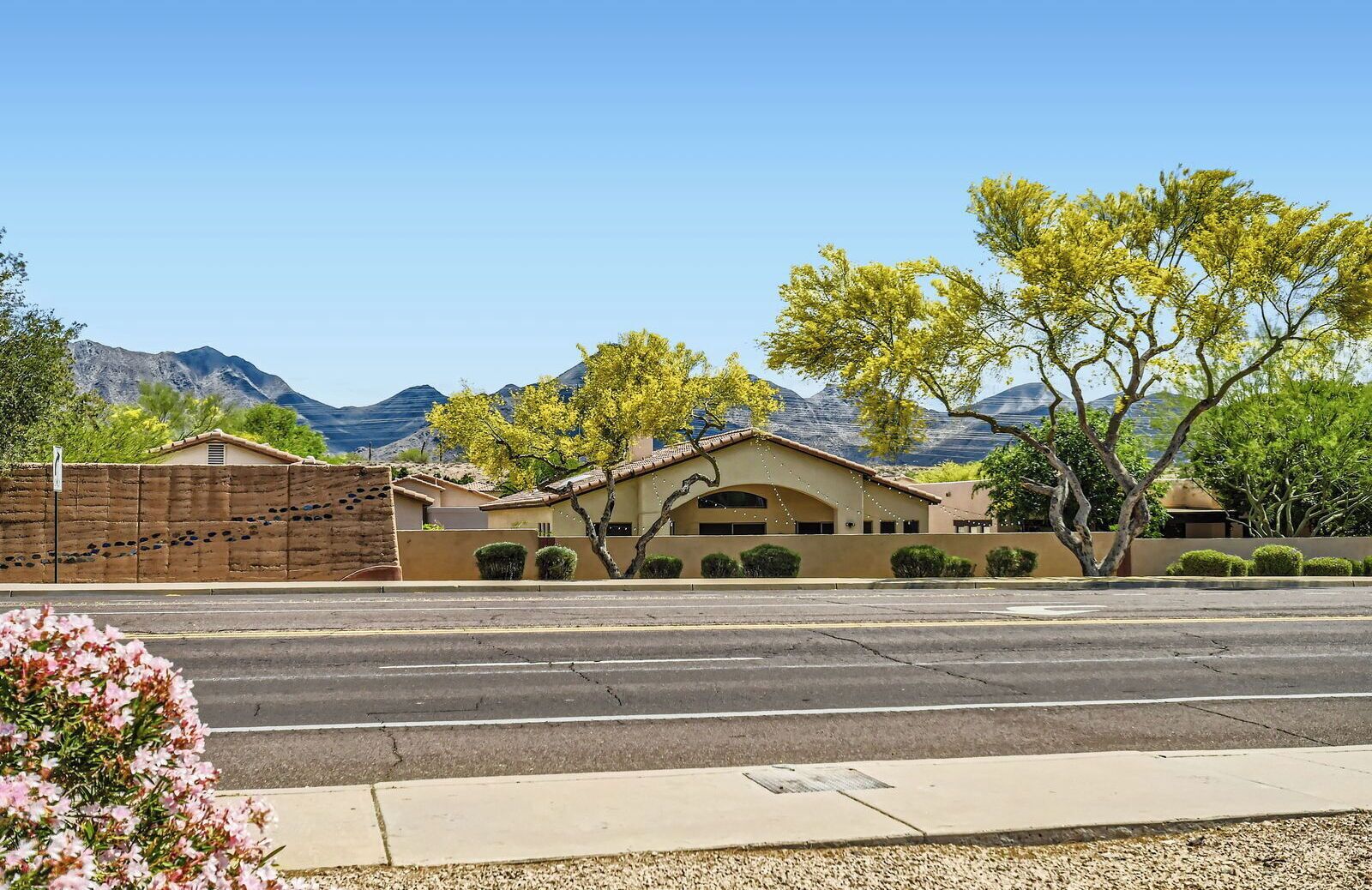 A two-story building with a flat roof and a central arched entrance.