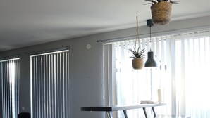 Et moderne køkken med en central ø, sorte stole og et spisebord.