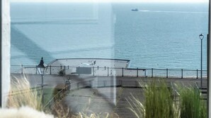 A view of the sea from a window overlooking a promenade with a railing and a lamp post. - The Wellington - style, charm, stunning sea views (Ramsgate)