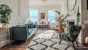A living room with a sofa, armchair, and a patterned rug. - The Wellington - style, charm, stunning sea views (Ramsgate)