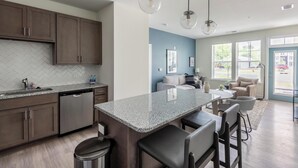 A modern kitchen with granite countertops, stainless steel appliances, and wooden cabinets.