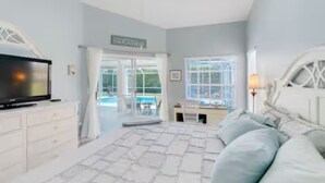 A bedroom with a bed, a TV, a desk, and a window with blinds. - Family Friendly Home in Naples, Near Beach, Heated Pool, Dog Friendly (Naples)