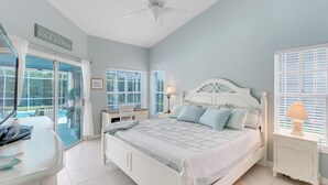 A bedroom with a bed, a desk, a chair, a ceiling fan, and a window with blinds. - Family Friendly Home in Naples, Near Beach, Heated Pool, Dog Friendly (Naples)