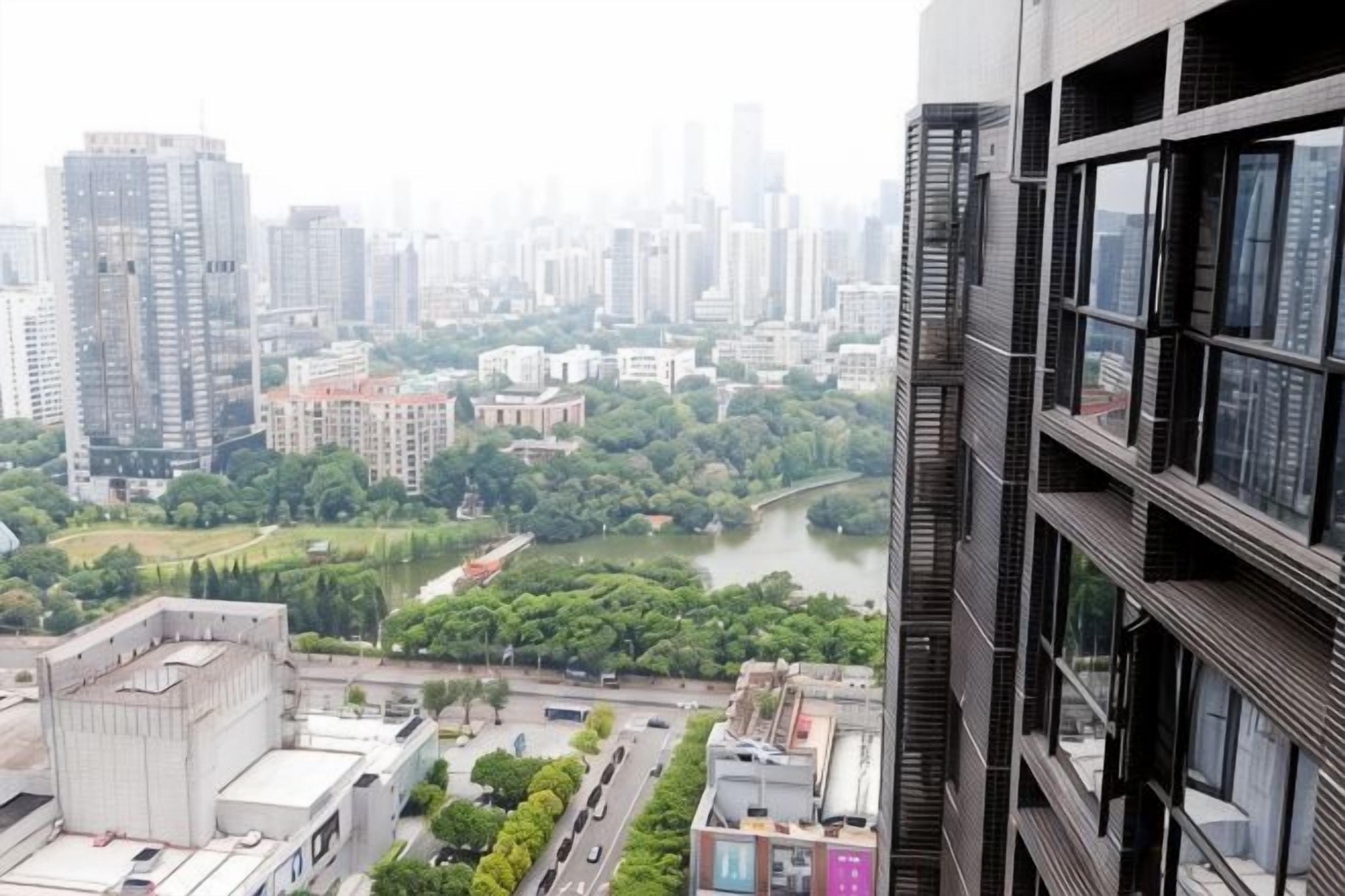 A high-rise building with multiple floors, a river in the background, and a cityscape.