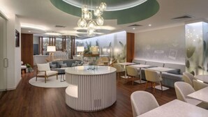 Een modern interieur met een ronde zithoek, een ronde tafel en een opvallend plafondontwerp.