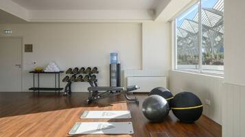 Une salle de sport équipée de matériel d’exercice, dotée d’un distributeur d’eau et offrant une vue sur l’extérieur.