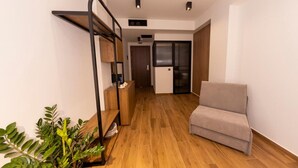 Eine moderne Wohnung mit Holzboden, Etagenbett, Sofa und einer Zimmerpflanze.