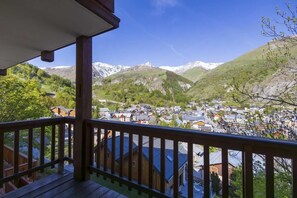 Eine Holzdielen-Terrasse mit Blick auf eine Bergstadt.