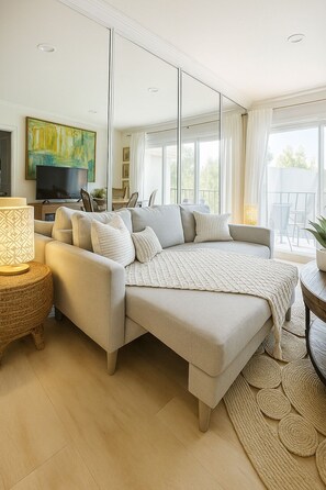 Una camera da letto moderna con un letto grande, una televisione e un balcone con mobili da esterno.