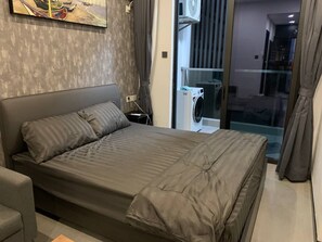 Une chambre moderne avec un grand lit, un petit canapé et une fenêtre avec des rideaux.