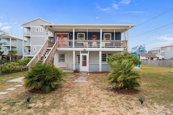 A two-story house with a front porch, a staircase, and a balcony.