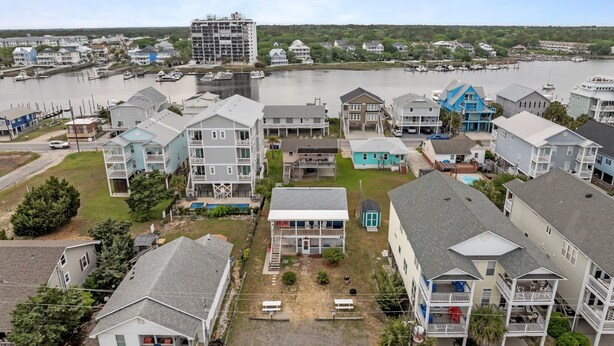 A coastal residential area with multiple two-story houses, a marina with boats, and a large building under construction. - Low Tide at Coral Reef  2 BDRM  1.5 bath Sleeps 5 with Linens Included! (Carolina Beach)