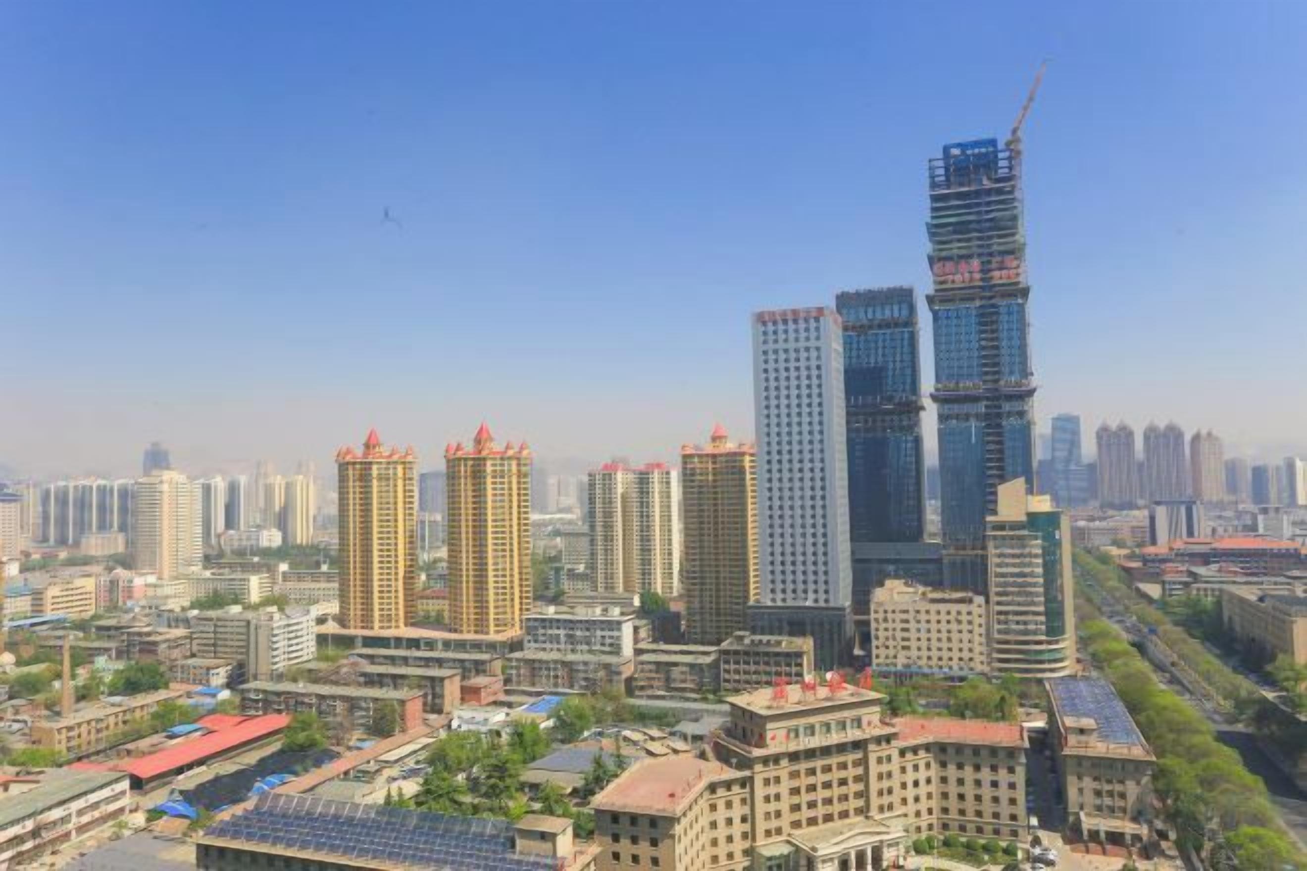 A cityscape with high-rise buildings, including a distinctive skyscraper under construction.