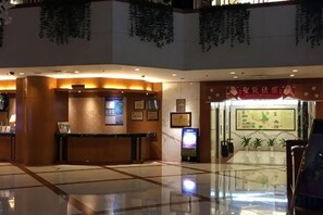 A hotel lobby with a reception desk, framed certificates, and a large wall with a traditional painting. - Lanzhou Legend Hotel (Lanzhou Railway Station & Lanzhou University Subway Station) (Lanzhou)