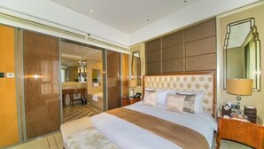 Une chambre d’hôtel avec un grand lit, une tête de lit en bois, une table de chevet avec une lampe et un miroir au mur.