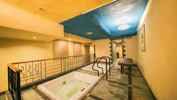 Un pasillo con zona de spa, que incluye un jacuzzi y una escalera que lleva a otro nivel.