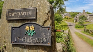 A signpost with 'DWYNANT' and 'TY-GLAN-AFON' indicating a location. - Ty Glan Yr Afon (Dolgellau)