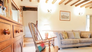 A cozy living room with a rocking chair, a wooden dresser, and a sofa. - Ty Glan Yr Afon (Dolgellau)