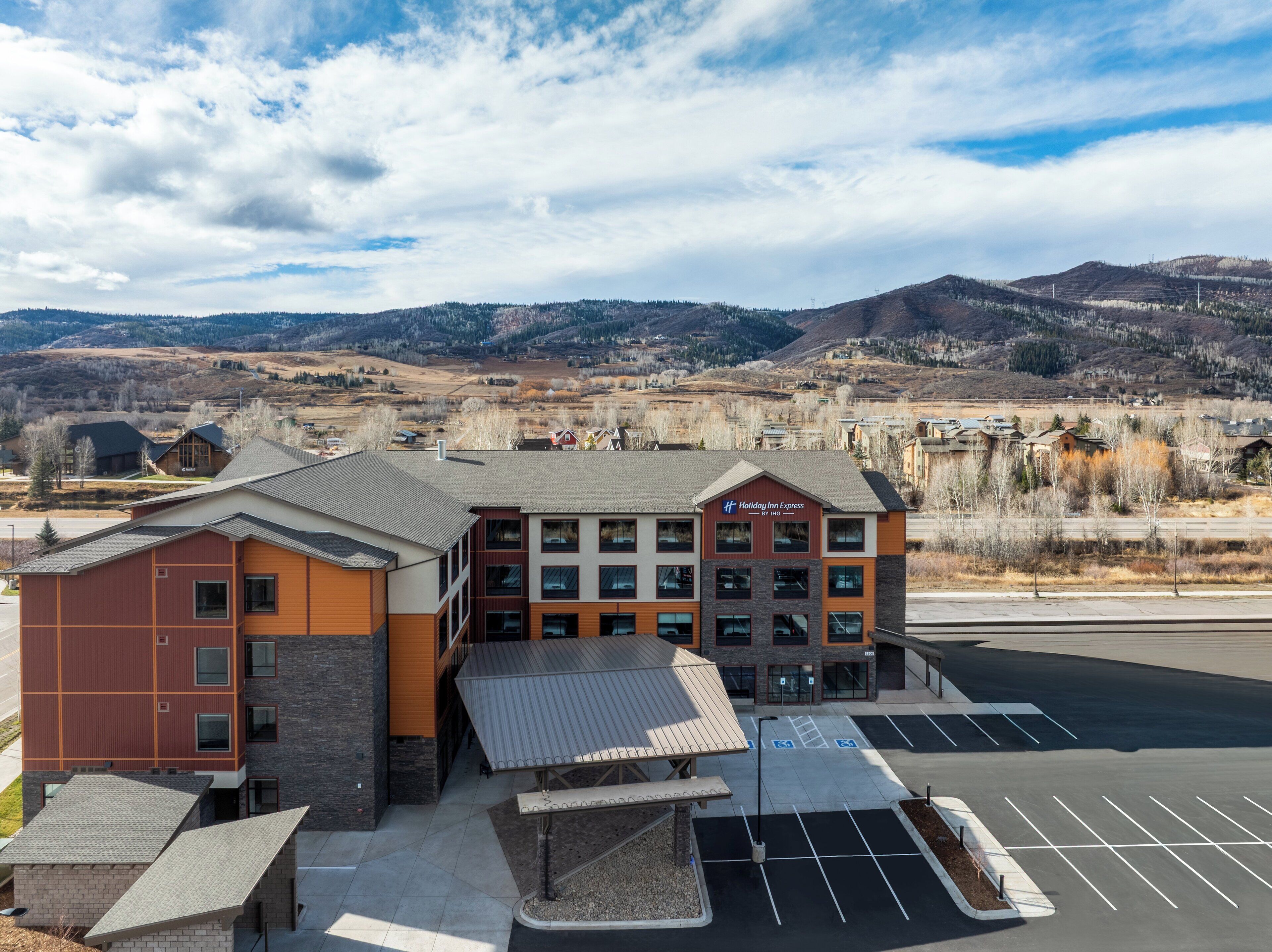 A Holiday Inn Express hotel with a parking lot and a view of the surrounding landscape.