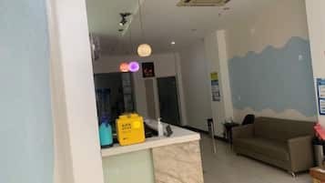 Uma área de recepção com balcão, sofá e painel com padrão de ondas.