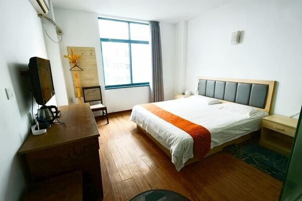 A hotel room with a bed, a desk, a chair, a television, a window, and a wardrobe. - Meilu Living Hotel (Shanghai)