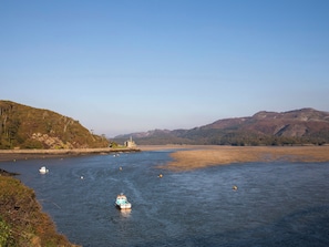 A river with boats, a distant building, and hills. - Briallen (Dolgellau)