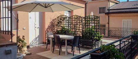 Enjoy meals al fresco on this balcony with a dining table and comfortable chairs.