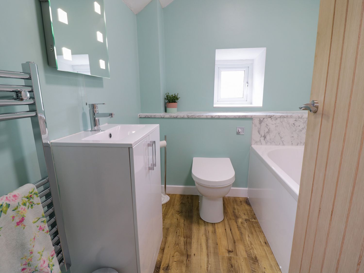 Un baño pequeño con un lavamanos, inodoro y bañera blancos.