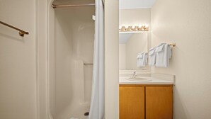 Un baño con bañera, cortina de ducha, lavabo y espejo.