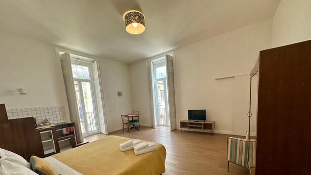 A bedroom with a bed, a desk, a chair, a TV, and a wardrobe. - The Romantic Apartment for two (Naples)