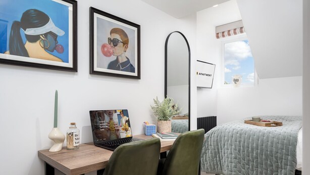 A bedroom with a bed, a desk with a laptop, two chairs, a mirror, and a window. - Camden | Room B2 - Studio Apartment, Sleeps 2 (London)
