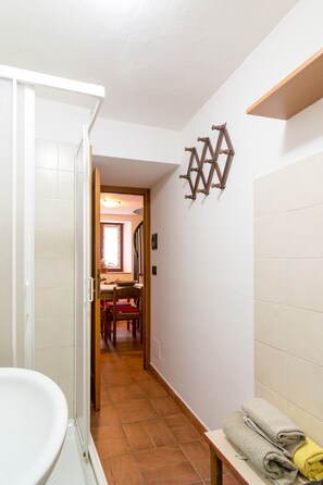 Une petite salle de bain avec une douche, un lavabo et un porte-serviettes.