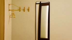A bathroom with a wall-mounted mirror, a towel rack, and a towel dispenser. - Compact Bunk Room in Arts District + Free Parking (San Juan)