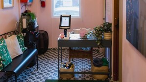 Un hall d’hôtel comprenant un comptoir d’accueil, un banc, un extincteur, une fenêtre avec vue et un tapis vert portant l’inscription « HOTEL LUZ Puerto Rico ».