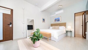 Une chambre d’hôtel avec un lit, une table de chevet, une lampe et une plante en pot.