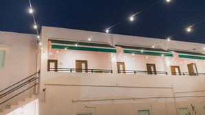 Un immeuble à plusieurs étages doté de balcons, de guirlandes lumineuses et d’un escalier.