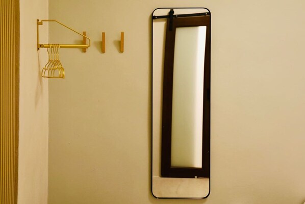A bathroom with a wall-mounted mirror, a towel rack, and a towel dispenser.
