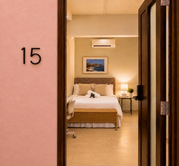 Ein Hotelzimmer mit Bett, Nachttisch, Lampe und einem Gemälde an der Wand.