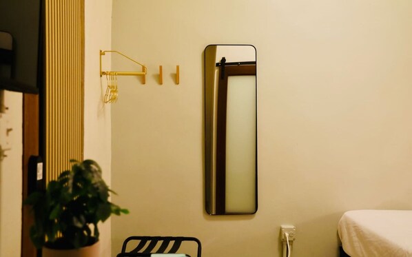 A bathroom with a mirror, a towel rack, and a potted plant. - Design-Forward Studio by Lagoon (San Juan)