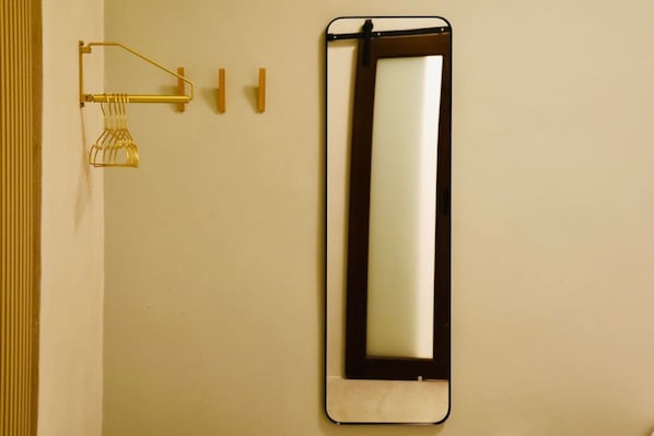 A bathroom with a wall-mounted mirror, a towel rack, and a towel dispenser. - Stylish Escape by Calle Cerra Art (San Juan)