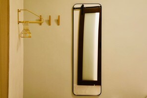 A bathroom with a wall-mounted mirror, a towel rack, and a towel dispenser. - Sleek & Serene Stay in San Juan (San Juan)