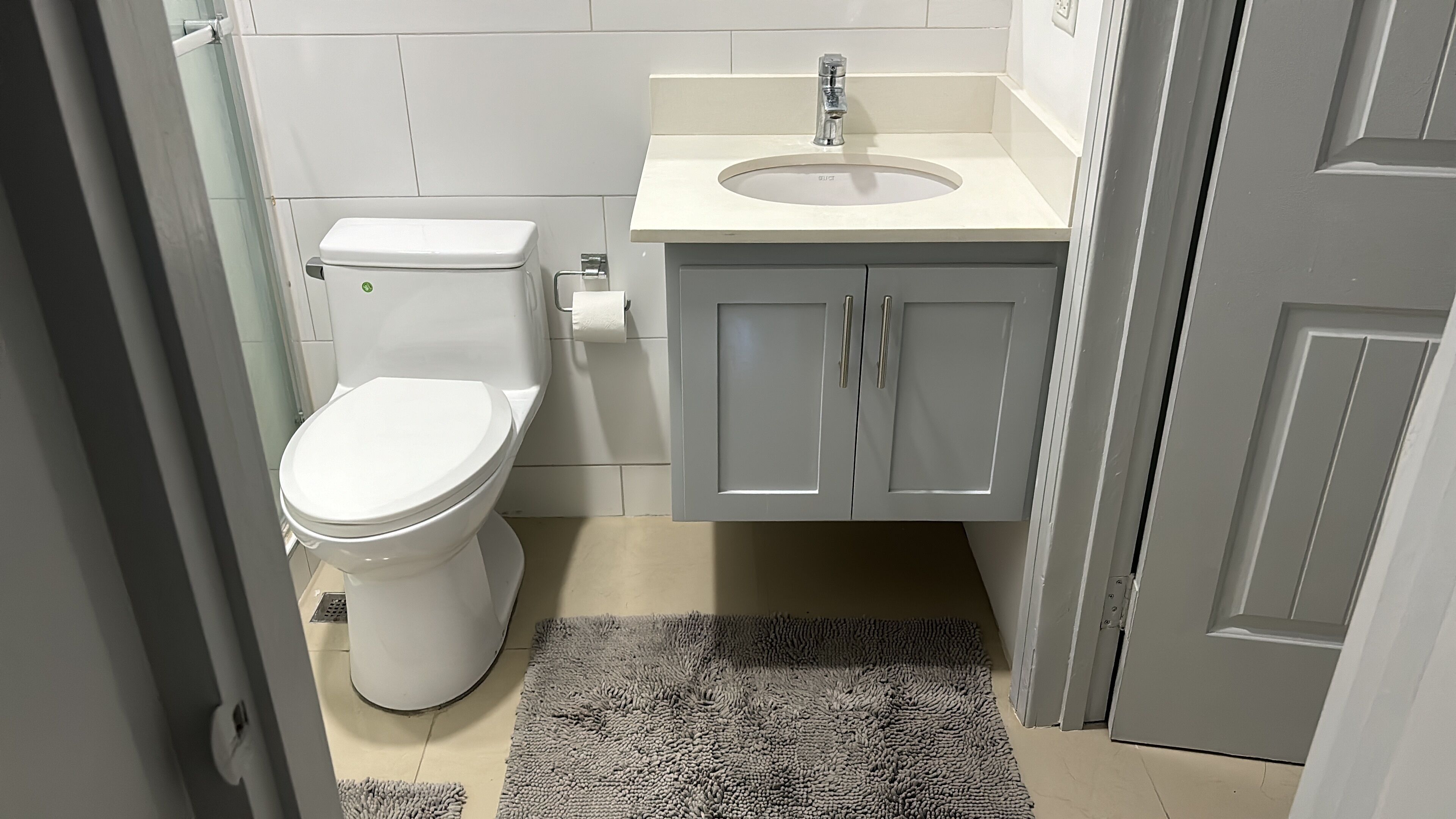 Een badkamer met toilet, wastafel en kast.