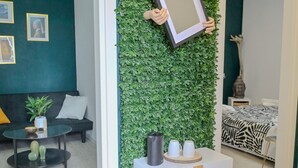 Un intérieur moderne avec un mur vert, une console blanche et un canapé.