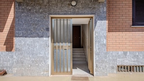 A building entrance with a metal gate, a staircase leading inside, and a concrete floor. - Magnolia House - Appartamento 1 (Tor Lupara)