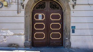 Una puerta doble grande y ornamentada con un cartel que prohíbe estacionar.