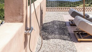 A rooftop terrace with a shower, a thatched umbrella, and a view of the sea. - Terracotta Fiscrdo Villas
 3 bedrooms (Fiscardo)