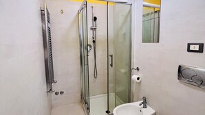 A bathroom with a glass-enclosed shower, a white sink, and a toilet. - L'affito Camera di Venezia (Mestre)